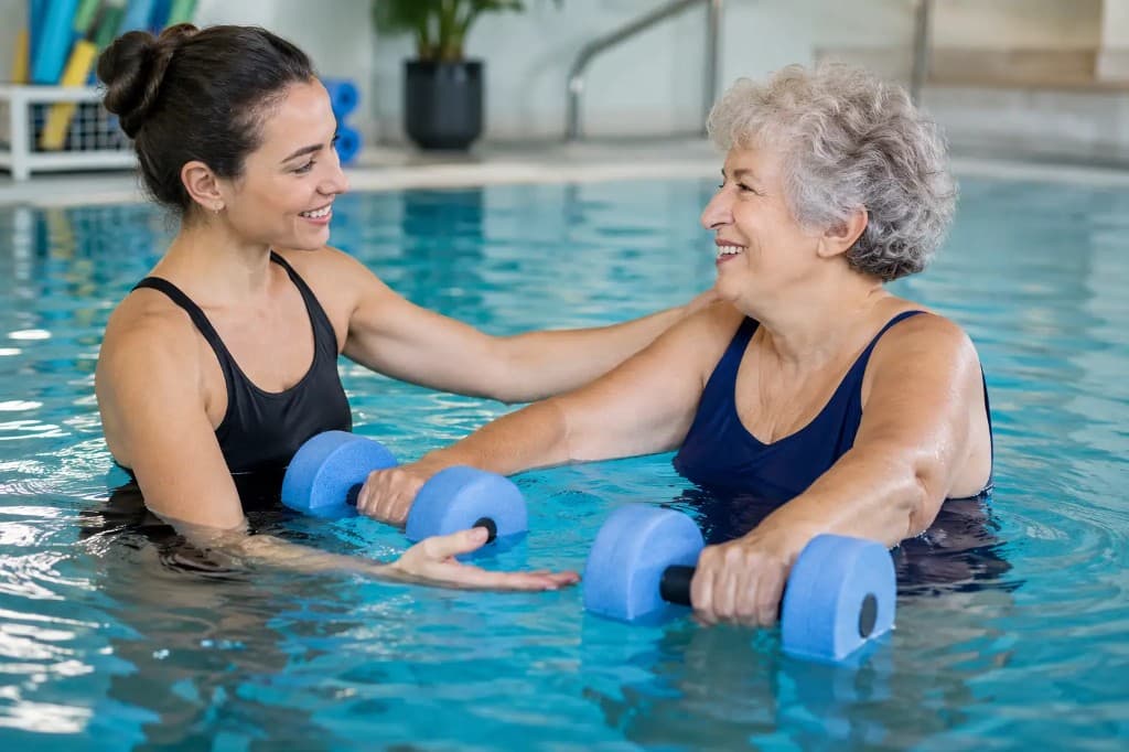 A senior performing gentle water-based exercises with an RST in a warm therapeutic pool